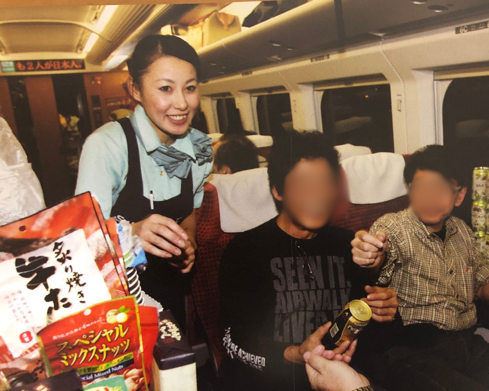新幹線車内で接客中の販売員とお客様の写真のイメージ画像